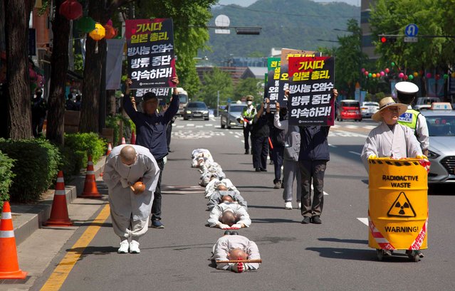 South Korean monks perform the Buddhist praying act of Dharna – walking three steps and making one bow – to protest against Japan's disposal of Fukushima radioactive water during a rally against the visit of the Japanese prime minister in Seoul, South Korea, 08 May 2023. Japanese Prime Minister Fumio Kishida is on a visit to South Korea from 07 to 08 May. (Photo by Jeon Heon-Kyun/EPA/EFE)