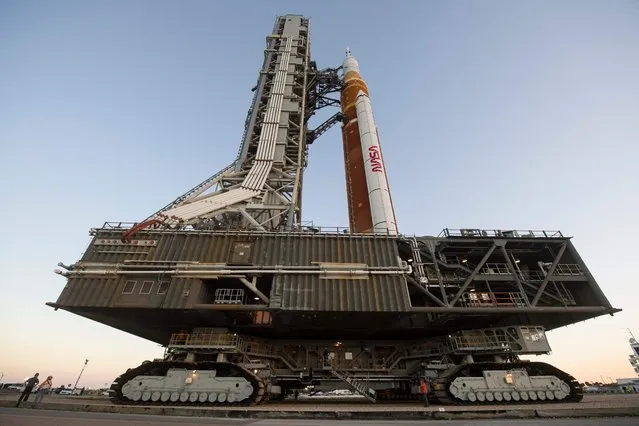 In this NASA handout photo NASA's Space Launch System (SLS) rocket with the Orion spacecraft aboard is seen atop a mobile launcher as it rolls out to Launch Complex 39B for the first time, March 17, 2022, at NASA's Kennedy Space Center in Florida. NASA's massive new rocket began its first journey to a launchpad on March 17, 2022 ahead of a battery of tests that will clear it to blast off to the Moon this summer. (Photo by Aubrey Gemignani/NASA via AFP Photo)