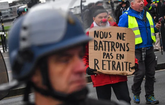 A man holds a placard with a word game in French reading “we shall not retreat” in front of a riot mobile gendarmes (L) on December 17, 2019 in Nantes during a demonstration as part of a third countrywide day of protests over a government pensions overhaul, with the government showing no signs it will give in to union demands to drop the plan. (Photo by Loic Venance/AFP Photo)