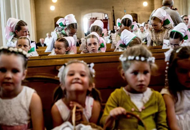 Catholic Sorbs in their traditional costumes attend a holy mass during a Corpus Christi procession in Crostwitz, Germany, 15 June 2017. The procession has been a tradition in Lusatia region. The Western Slavic people of the Sorbs are acknowledged as a national minority with their own language in eastern Germany. (Photo by Filip Singer/EPA)