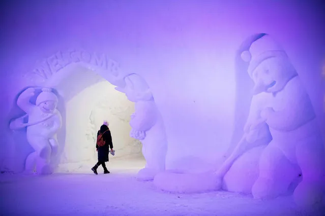 A tourist visits an ice structure at the Santa Claus Village near Rovaniemi, Finnish Lapland, on December 2, 2019. Rovaniemi's Santa Claus Village amusement park is a snow-covered wonderland of reindeer rides, ice castles, souvenir shops, snowmobiles and igloo hotels where Christmas holds sway 365 days a year. But Lapland is also the homeland of the indigenous reindeer-herding Sami people, who protest that some in the tourist industry spread offensive stereotypes about Sami people and seek to profit from their ancient culture. (Photo by Jonathan Nackstrand/AFP Photo)