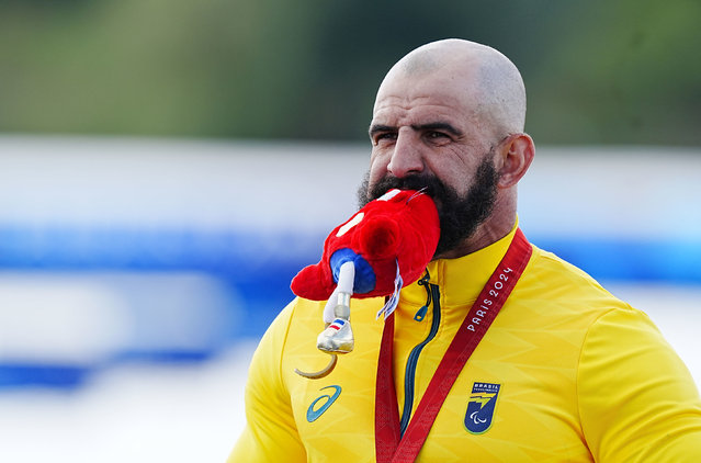 Brazil's Fernando Rufino de Paulo on the podium with the Phrygian cap mascot after winning gold in the Men's Va'a Single 200m - VL2 Final at the Vaires-sur-Marne Stadium on day eleven of the Paris 2024 Summer Paralympic Games on Sunday, September 8, 2024. (Photo by Adam Davy/PA Images via Getty Images)