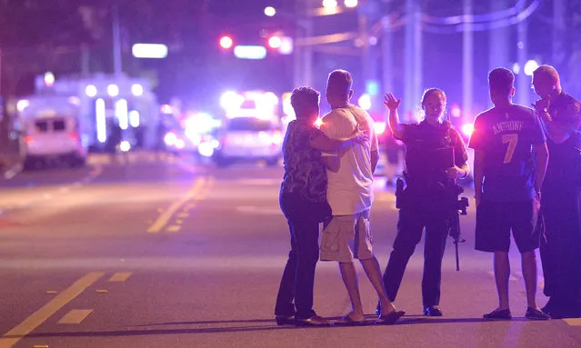 Orlando Police officers direct family members away from a multiple shooting at a nightclub in Orlando, Fla., Sunday, June 12, 2016. A gunman opened fire at a nightclub in central Florida, and multiple people have been wounded, police said Sunday. (Photo by Phelan M. Ebenhack/AP Photo)
