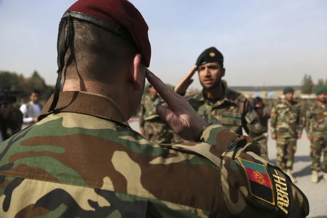 An Afghan National Army soldier, center, salutes to his commander during a graduation ceremony from a three-month training program at the Afghan Military Academy in Kabul, Afghanistan, Monday, October 28, 2019. (Photo by Rahmat Gul/AP Photo)
