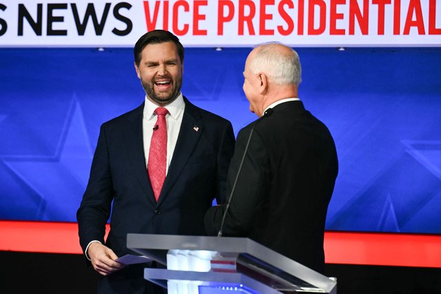 US Senator and Republican vice presidential candidate J.D. Vance (L) and Minnesota Governor and Democratic vice presidential candidate Tim Walz talk with each other at the end of the Vice Presidential debate hosted by CBS News at the CBS Broadcast Center in New York City on October 1, 2024. (Photo by Angela Weiss/AFP Photo)