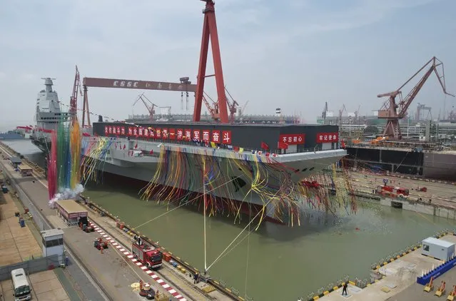 In this photo released by Xinhua News Agency, coloured smoke mark the launch ceremony for China's third aircraft carrier christened Fujian at a dry dock in Shanghai on Friday, June 17, 2022. China on Friday launched its third aircraft carrier, the first such ship to be both designed and built entirely within the country. (Photo by Li Gang/Xinhua via AP Photo)