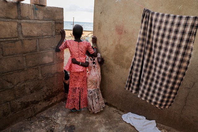 Girls watch from afar a soccer game between two teams from the neighborhood in Toubab Dialaw on the outskirts of Dakar, Senegal, on September 25, 2024. (Photo by Zohra Bensemra/Reuters)