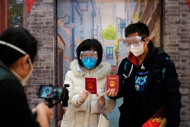 Jia, 29, and his wife Su, 28, poses with face masks and marriage certificates at a marriage registry office on Valentine's Day in Shanghai, China, as the country is hit by an outbreak of the novel coronavirus, February 14, 2020. (Photo by Aly Song/Reuters)