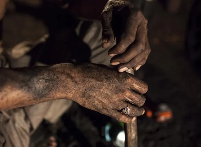 A miner covered in coal dust sits inside a mine in Choa Saidan Shah, Punjab province, April 29, 2014. (Photo by Sara Farid/Reuters)