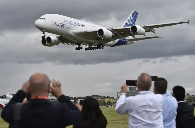 Plane enthusiasts watch an Airbus A-380 during a flight demonstration at the Farnborough International Airshow, in Farnborough, Britain, 11 July 2016. The Farnborough International Air Show runs from 11 to17 July 2016. (Photo by Hannah Mckay/EPA)