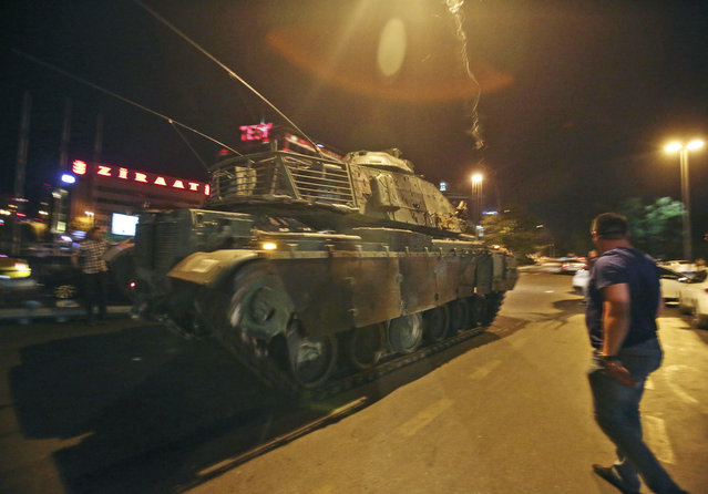 A tank moves into position as Turkish people attempt to stop them, in Ankara, Turkey, early Saturday, July 16, 2016. Turkey's armed forces said it “fully seized control” of the country Friday and its president responded by calling on Turks to take to the streets in a show of support for the government. A loud explosion was heard in the capital, Ankara, fighter jets buzzed overhead, gunfire erupted outside military headquarters and vehicles blocked two major bridges in Istanbul. (Photo by AP Photo)