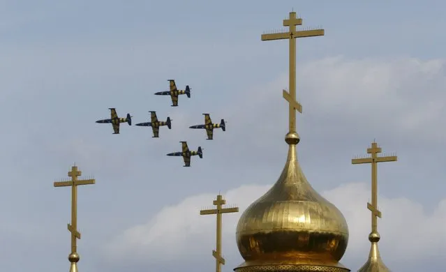 Latvia's Baltic Bees aerobatic team fly on L-39 Albatross jet trainer aircraft over the domes of an Orthodox church during the MAKS International Aviation and Space Salon in Zhukovsky, outside Moscow, Russia, August 28, 2015. (Photo by Sergei Karpukhin/Reuters)