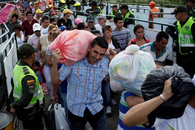 People are seen carrying bags and packages as they cross the Colombian-Venezuelan border over the Simon Bolivar international bridge after shopping in Cucuta, Colombia, July 17, 2016. (Photo by Carlos Eduardo Ramirez/Reuters)