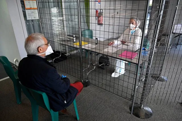 A doctor (L) shows the welcome desk of a consultation centre dedicated to covid19 suspected patients in Tinteniac, western france on March 27, 2020. This consultation centre is located  in a intermunicipal venue to remove patients at risk of infection from doctors' offices in order to continue caring for other patients. (Photo by Damien Meyer/AFP Photo)