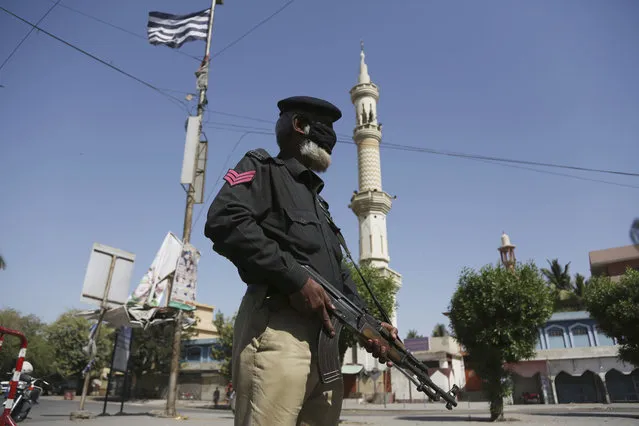 A police officer stands guard outside a mosque during a lockdown to help curb the spread of the coronavirus in Karachi, Pakistan, Friday, March, 3, 2020. Some mosques were allowed to remain open in Pakistan on Friday, the Muslim sabbath when adherents gather for weekly prayers, even as the coronavirus pandemic spread and much of the country had shut down. (Photo by Fareed Khan/AP Photo)