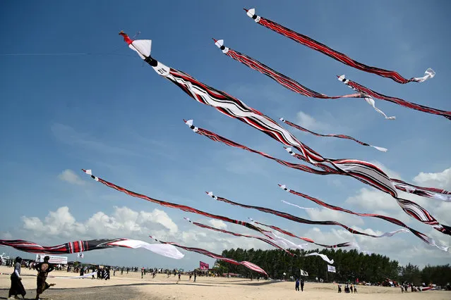 People fly their kites during the Kite Festival at Mertasari beach in Sanur on the Indonesian resort island of Bali on July 31, 2022. (Photo by Sonny Tumbelaka/AFP Photo)