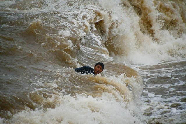 A man swims despite a storm warning as Tropical Storm John is on track to become a hurricane again, hurtling back towards communities across the Pacific coast, in Acapulco, Mexico, on September 25, 2024. (Photo by Javier Verdin/Reuters)