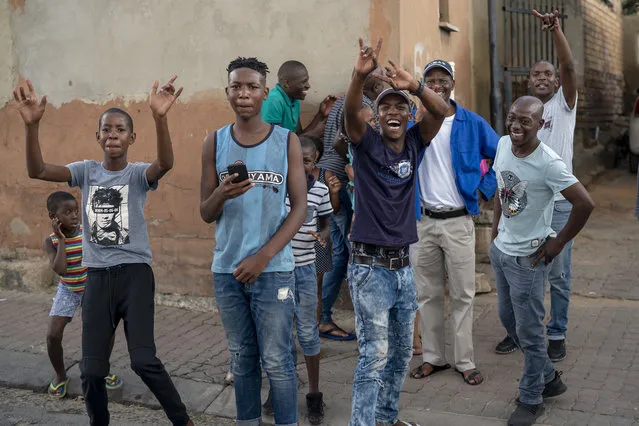 Young residents of the densely populated Alexandra township east of Johannesburg cheer at the photographer following a South African National Defense Forces patrol Friday, March 27, 2020. (Photo by Jerome Delay/AP Photo)