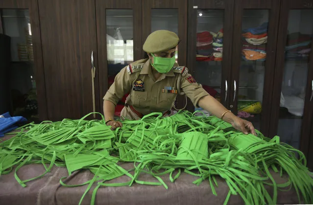 An officer checks the quality as Jammu and Kashmir police personnel make face masks and personal protective gear amid COVID-19 outbreak in Jammu, India, Wednesday, April 8, 2020. (Photo by Channi Anand/AP Photo)