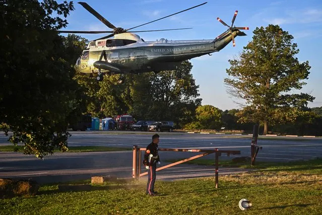 A US Marines hat is blown off as US President Joe Biden takes off from Brandywine Creek State Park in Marine One in Wilmington, Delaware on August 20, 2022. (Photo by Jim Watson/AFP Photo)