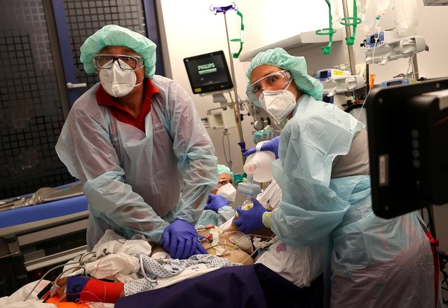 Doctor Katharina Franz and paramedic Andreas Hankel, of the rescue helicopter “Christoph Giessen”, reanimate a patient during preparations for his transport in the special isolation chamber “IsoArk”, for highly infectious coronavirus disease (COVID-19) patients, from a clinic in Hanau, Germany, April 16, 2020, as the spread of the coronavirus disease (COVID-19) continues. (Photo by Kai Pfaffenbach/Reuters)