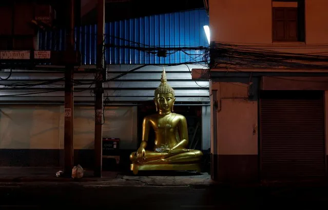 A religious statue is seen in an empty street as Thailand will impose a nationwide night curfew from Friday April 3, to try to curb the spread of the coronavirus disease (COVID-19) outbreak in Bangkok, Thailand, April 2, 2020. (Photo by Jorge Silva/Reuters)
