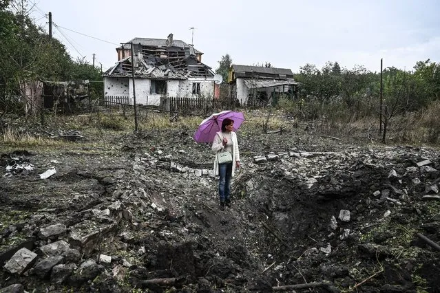 A woman stands in front of a destroyed house, in Kramatorsk, Donetsk region, on September 12, 2022, amid the Russian invasion of Ukraine. (Photo by Juan Barreto/AFP Photo)
