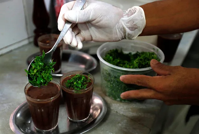 A man prepares a soup of beans as part of the Brazilian traditional dish called feijoada at the Bar do Mineiro in Rio de Janeiro, Brazil, March 24, 2016. (Photo by Sergio Moraes/Reuters)