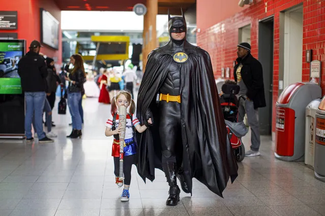 A father dressed as Batman takes her daughter dressed as Harley Quinn to the MCM Comic Con at ExCeL exhibition centre in London on October 29, 2017. (Photo by Tolga Akmen/AFP Photo)
