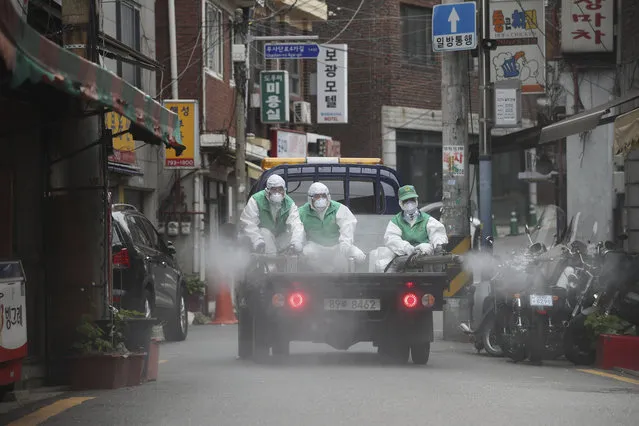 People wearing protective gears spray disinfectant as a precaution against the new coronavirus in Seoul, South Korea, Tuesday, May 12, 2020. (Photo by Im Hwa-young/Yonhap via AP Photo)