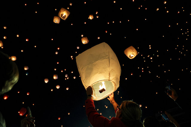 A person releases a sky lantern during Christmas festivities, in Athens, Greece on December 24, 2023. (Photo by Louiza Vradi/Reuters)