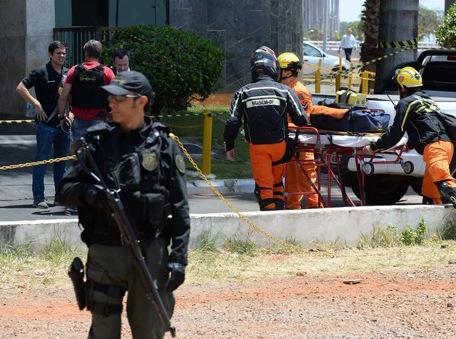 Police special forces are deployed at a hotel where an unidentified man keeps a hotel employee with an explosive-laden vest at a balcony of the hotel in Brasilia on September 29, 2014. (Photo by Evaristo Sa/AFP Photo)