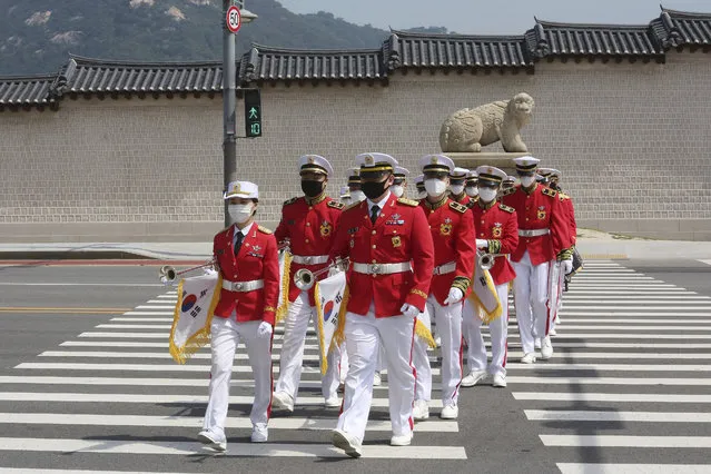 Members of the South Korean military band wearing face masks to help protect against the spread of the new coronavirus cross a road during an event to commemorate the upcoming 70th anniversary of the Korean War, in Seoul, South Korea, Monday, June 15, 2020. (Photo by Ahn Young-joon/AP Photo)