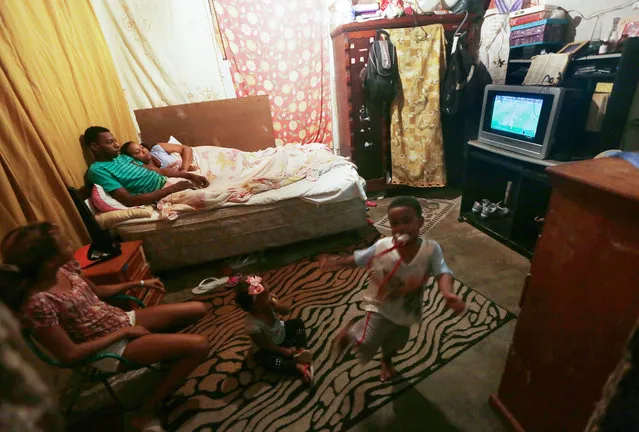 Brazilians gather and watch their team playing Germany in an occupied building in the Mangueira “favela” community on August 20, 2016 in Rio de Janeiro, Brazil. The “favela” is located about one kilometer from Maracana stadium, where the game was held. Yet most residents were not able to attend the match due to high ticket prices. Brazil won their first gold medal in soccer and avenged their humiliating 7-1 loss to Germany in the 2014 World Cup. (Photo by Mario Tama/Getty Images)