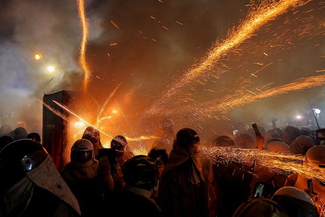 People wear protective gear as firecrackers explode during the Yanshui Beehive Fireworks Festival as part of the Lantern Festival celebrations in Tainan, Taiwan on February 11, 2025. (Photo by Ann Wang/Reuters)