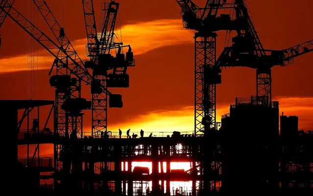 Workers are seen as the sun sets behind a construction site in London, Britain, January 21, 2020. (Photo by Henry Nicholls/Reuters)