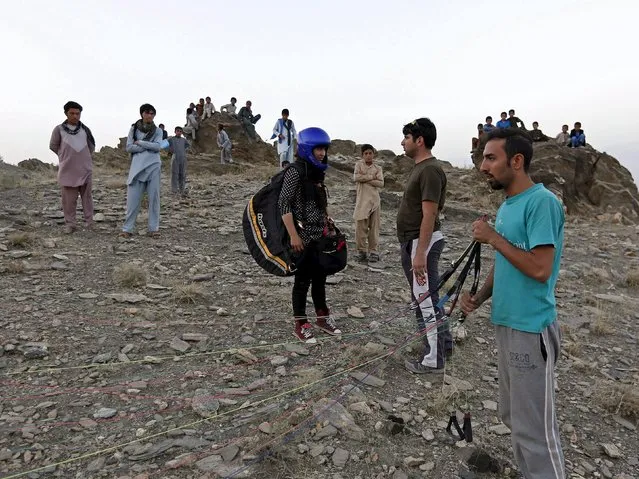 Afghan paraglider Leeda Ozori, 21, (C) prepares to take flight in Kabul, Afghanistan September 17, 2015. (Photo by Mohammad Ismail/Reuters)