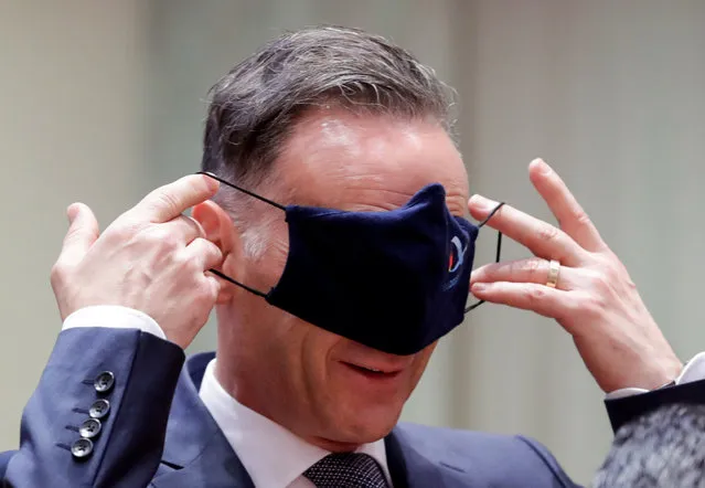 German Foreign Minister Heiko Maas puts his protective mask on his eyes while he attends a meeting of EU foreign ministers at the European Council building in Brussels, Belgium on July 13, 2020. (Photo by Stephanie Lecocq/Pool via Reuters)