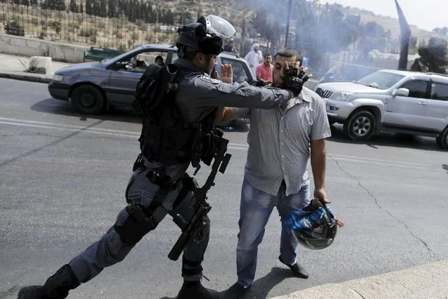 An Israeli policeman scuffles with a Palestinian man during clashes near the Arab East Jerusalem neighbourhood of Wadi al-Joz October 2, 2015. (Photo by Ammar Awad/Reuters)