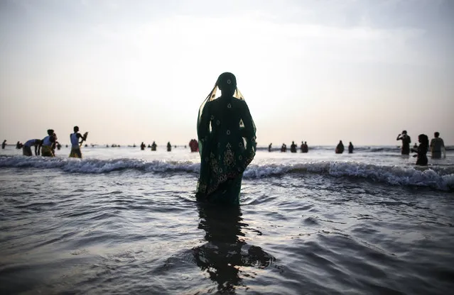 A Hindu devotee prays while standing in the waters of the Arabian Sea as she worships the Sun god Surya during the Hindu religious festival Chatt Puja in Mumbai October 29, 2014. (Photo by Danish Siddiqui/Reuters)