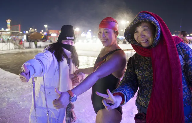 A winter swimmer takes photo with tourists at Ice and Snow World park on January 4 2018 in Harbin, China. The Ice and Snow World Park will host the 34th Harbin International Ice and Snow Sculpture Festival from Jan. 5 until the end of February. (Photo by Tao Zhang/Getty Images)