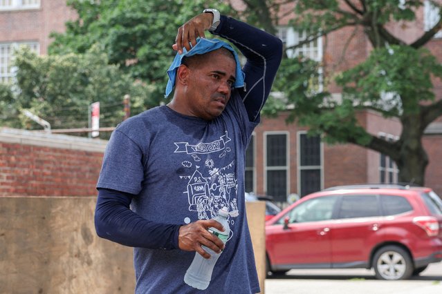 A landscaper puts a cold towel over his head as an extreme heat warning is in effect in Queens, New York City on June 23, 2025. (Photo by Kylie Cooper/Reuters)