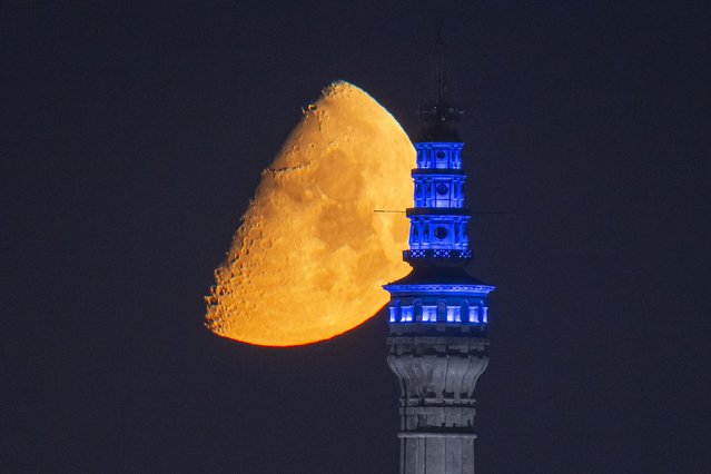 A half-moon is seen above the Beyazit Fire Tower in Istanbul, Turkiye, on July 3, 2025. (Photo by Isa Terli/Anadolu via Getty Images)
