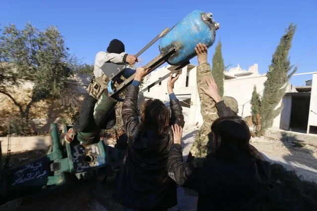 Fighters from the Noureddine Zanki movement, which operates under the Free Syrian Army, prepare an improvised explosive to fire towards forces loyal to Syria's President Bashar al-Assad at the frontline in Aleppo's al-Rashideen neighbourhood November 27, 2014. (Photo by Hosam Katan/Reuters)