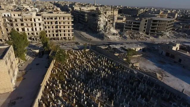 A still image taken on September 27, 2016 from a drone footage obtained by Reuters shows a cemetery surrounded by damaged buildings in a rebel-held area of Aleppo, Syria. (Photo by Reuters TV)