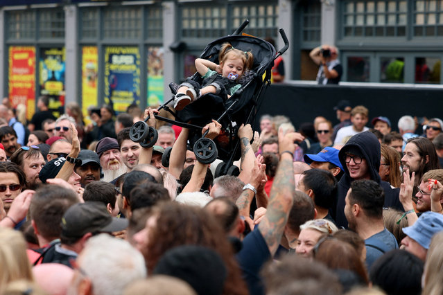 A child is carried out of the crowd as people gather on the day of the funeral cortege of the former Black Sabbath frontman Ozzy Osbourne, in Birmingham, Britain, on July 30, 2025. (Photo by Jack Taylor/Reuters)