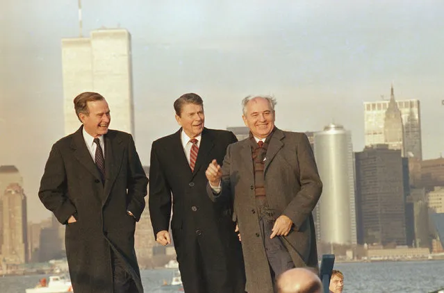 Soviet leader Mikhail Gorbachev points to photographer while viewing New York harbor with President Ronald Reagan and President-elect George H. Bush on Wednesday, December 7, 1988 in New York. In the background is Manhattan, including the Twin Towers of the World Trade Center, left. (Photo by Scott Applewhite/AP Photo)
