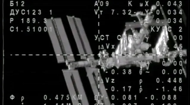 This image provided by NASA-TV shows the view from the Soyuz capsule as it approaches the International Space Station Thursday March 28, 2013. Chris Cassidy of the United States and Russians Pavel Vinogradov and Alexander Misurkin traveled six hours in the capsule before linking up with the space station's Russian Rassvet research module over the Pacific Ocean, just off Peru. It was the first time a space crew has taken such a direct route to the orbiting lab. Cassidy, Vinogradov and Misurkin are the first crew to reach the station after only four orbits instead of the standard 50-hour flight to reach the station. (Photo by AP Photo/NASA/The Atlantic)