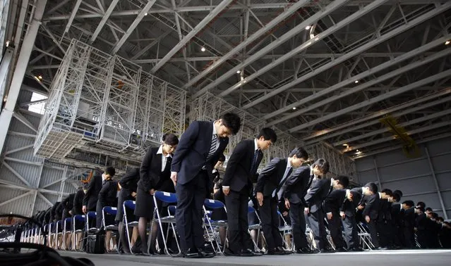 Newly hired employees of All Nippon Airways and ANA group companies bow during an initiation ceremony at the company’s aircraft maintenance hangar at Haneda airport in Tokyo on Monday, April 1, 2013. A total 1,068 new recruits attended the ceremony. (Photo by Junji Kurokawa/AP Photo)