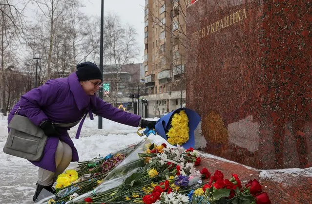 A visitor places flowers at a monument to Ukrainian poet Lesya Ukrainka on the first anniversary of the beginning of Russia's military campaign in Ukraine, in Moscow, Russia on February 24, 2023. (Photo by Reuters/Stringer)